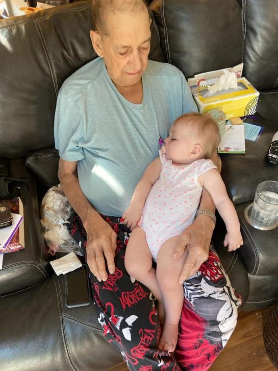 An old man holding a baby