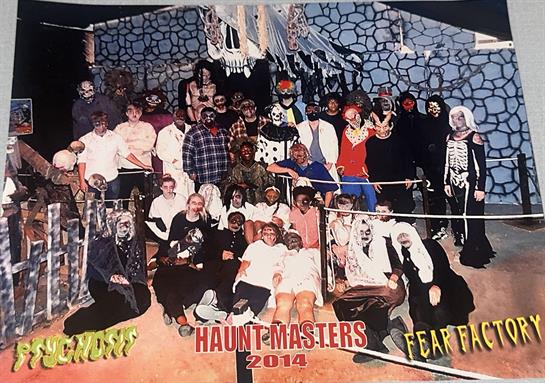 A large group of people gathered, showcasing various creative costumes in a spooky setting.