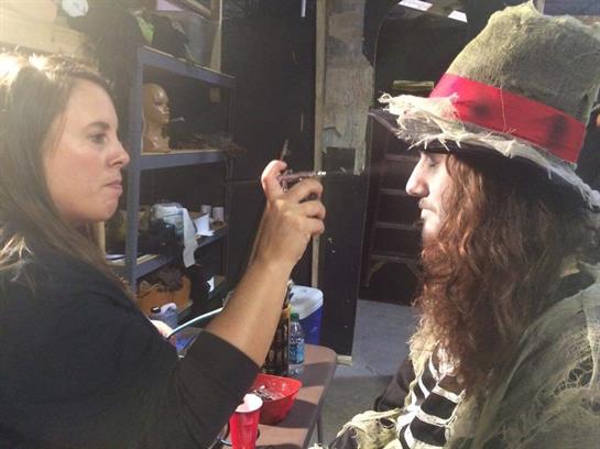 A makeup artist adds final touches to a performer's face before the show.