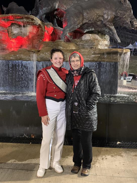 A woman standing next to a woman in front of a fountain