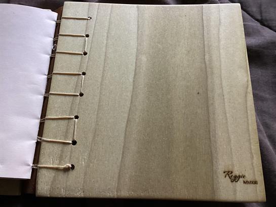 Blank wooden scrapbook with binding showing natural texture, perfect for custom pages and keepsakes.