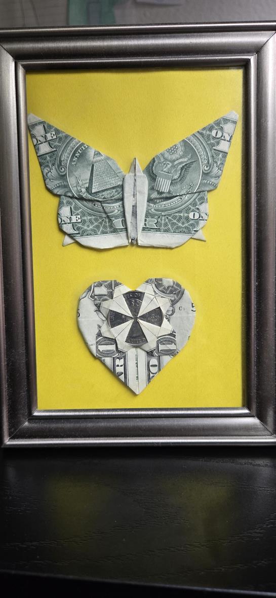 Currency-shaped art featuring a butterfly and heart, displayed against a bright yellow background.