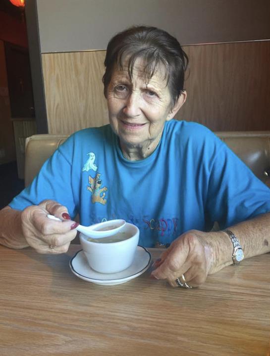 A woman sitting at a table with a spoon in her hand