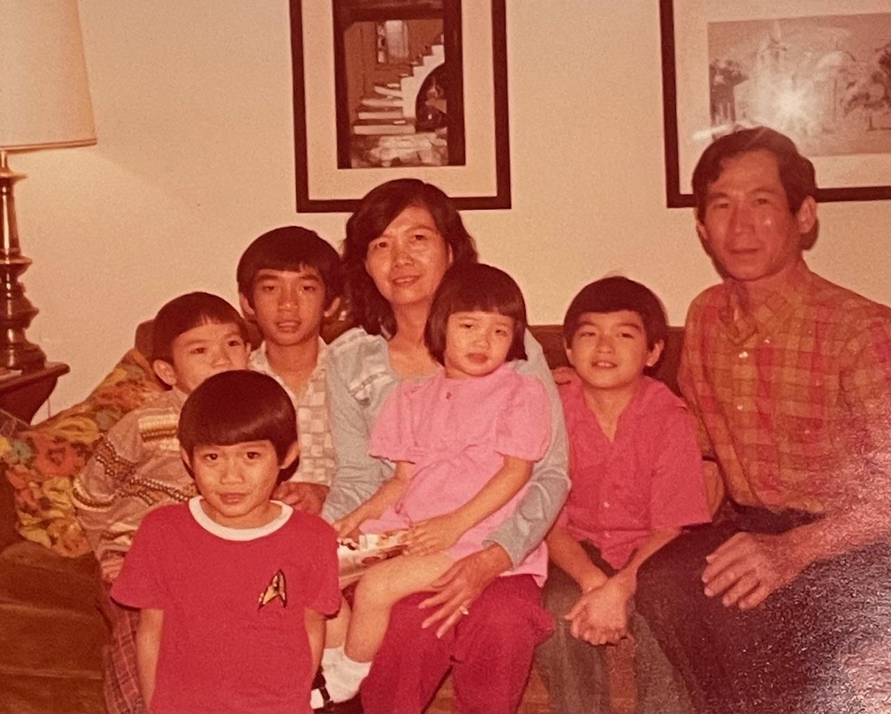 A family of seven enjoys their time together in a living room, showcasing warmth and joy.