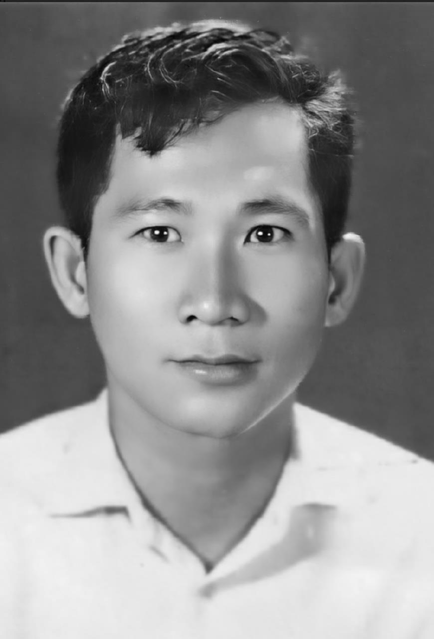 A young man appears in a formal portrait with a neutral expression, showcasing his style.