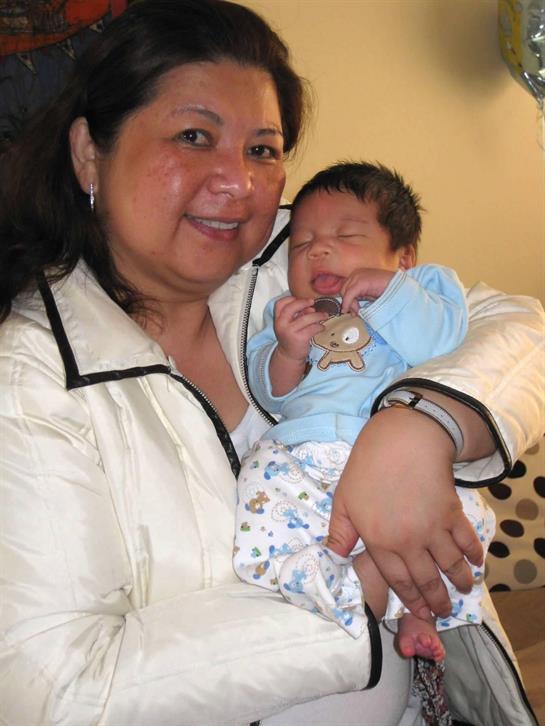 A joyful mother embraces her sleeping newborn in a warm and loving environment.