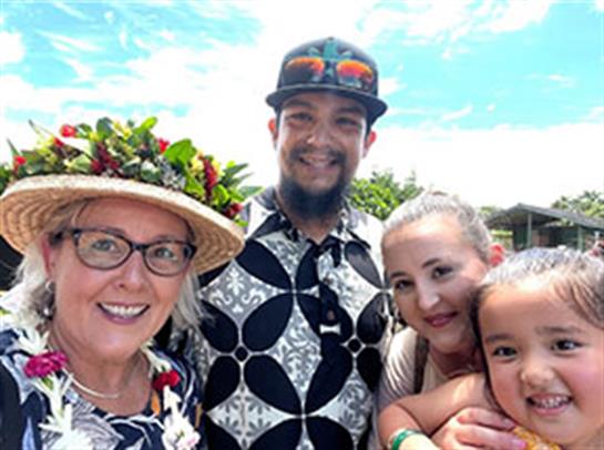A joyful family captures a moment together during a celebration surrounded by lush greenery.