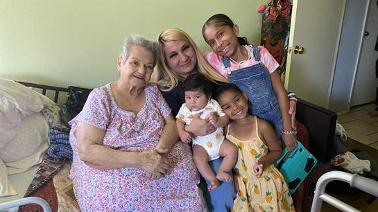 A grandmother, mother, and two young girls gather together, showcasing family bonds and warmth.