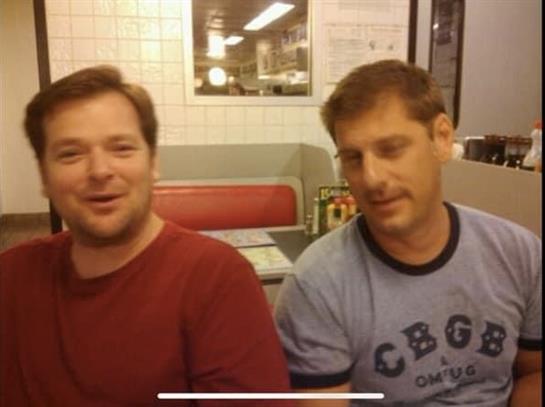 Friends laugh and chat in a cozy diner setting during a relaxed evening outing.