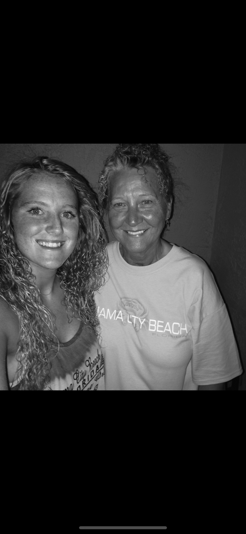 Two women enjoy a cheerful moment smiling together during their vacation in Panama City Beach.