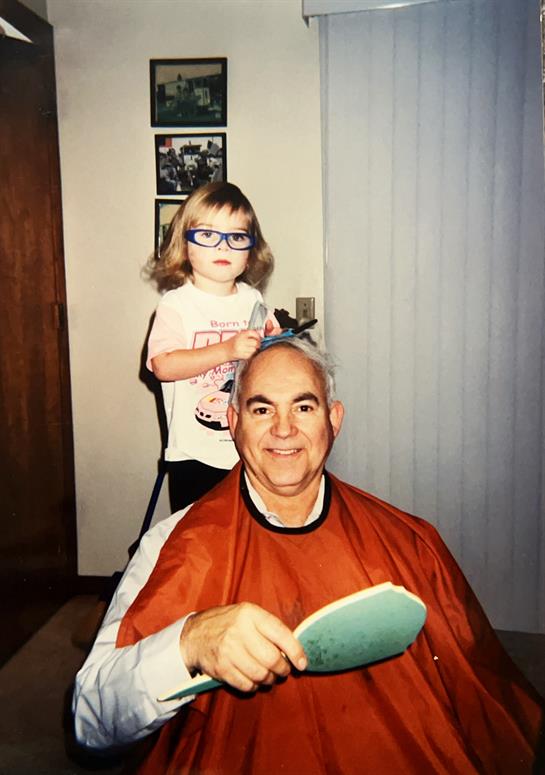 A girl standing behind a man's hair