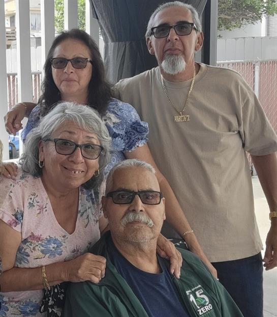 Four family members enjoying their time together in an outdoor space filled with smiles.