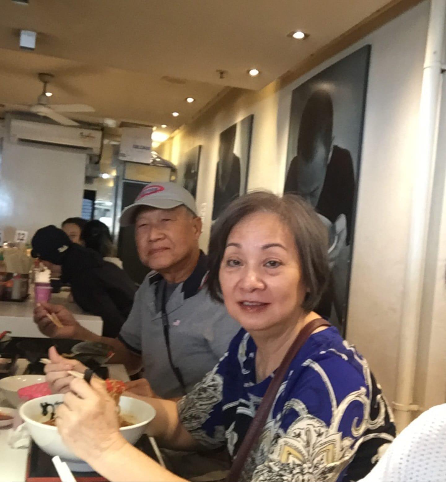 A couple shares a joyful moment while dining at a busy restaurant, savoring their meal.