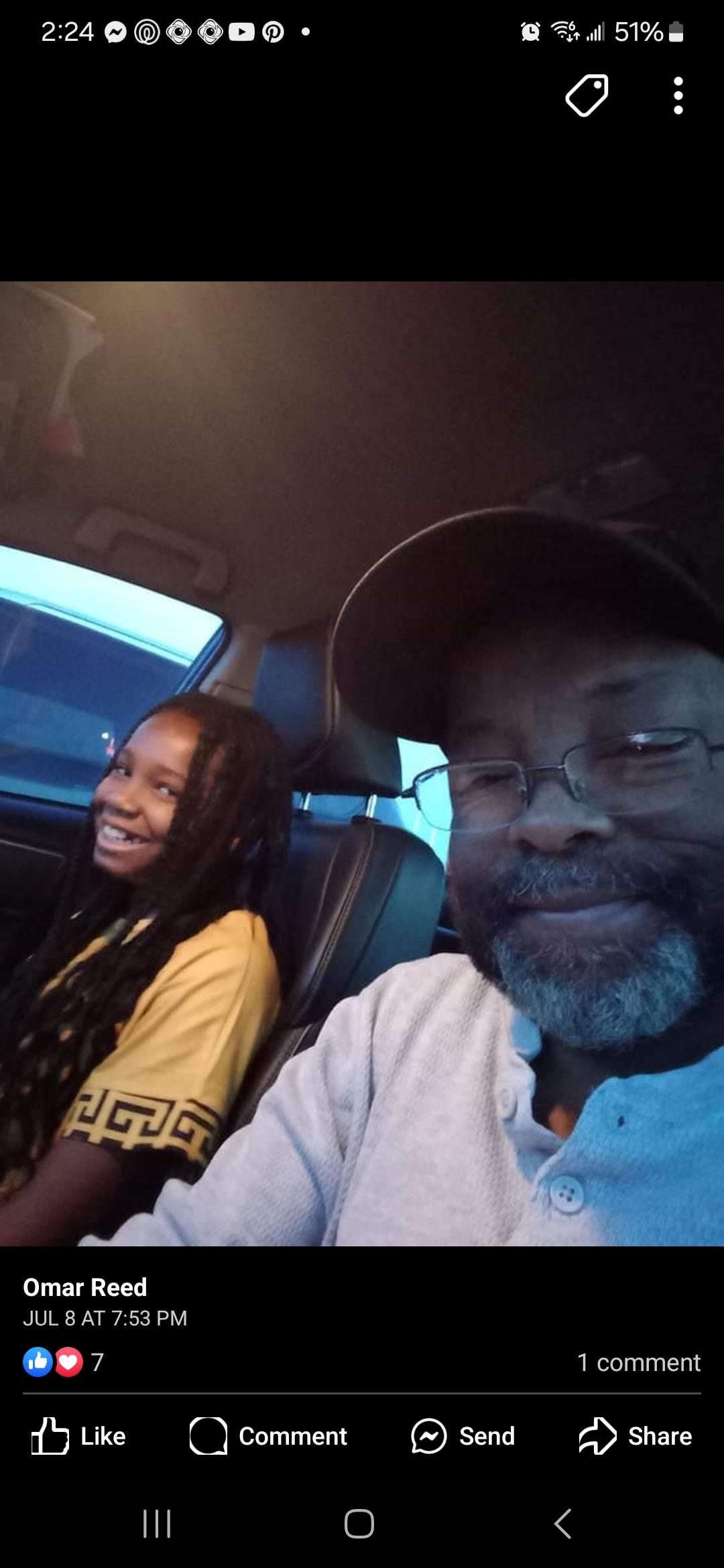 A young girl beams with joy next to her father while enjoying a car ride together.