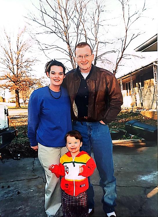A man and woman standing next to a child