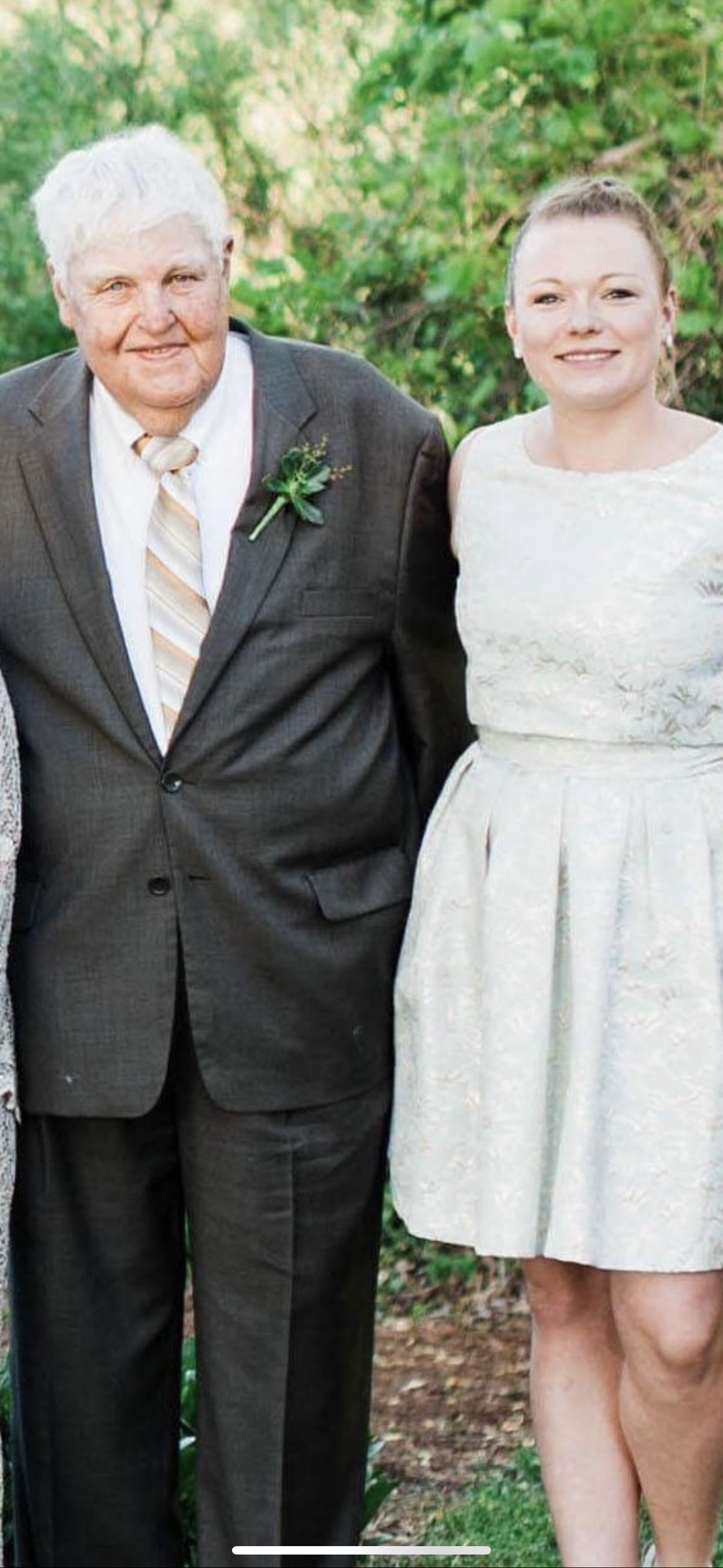 Three family members pose together in a lush garden, celebrating a special occasion in their attire.