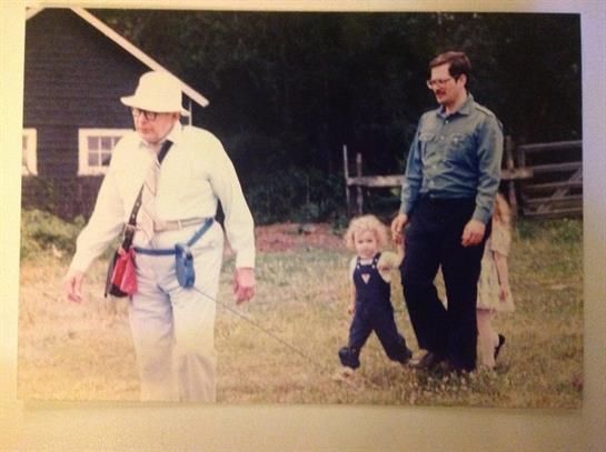 Four family members enjoy a leisurely walk in the countryside on a sunny day.