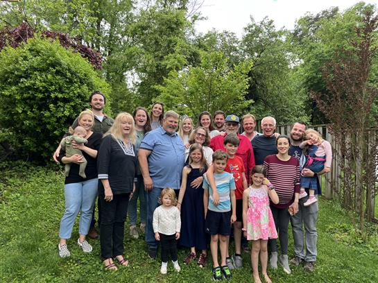 Family members gather in a vibrant backyard enjoying each other's company during summer.