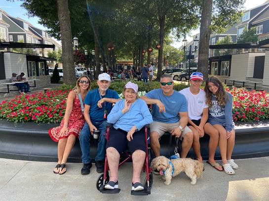 A group of people sitting on a bench with a dog