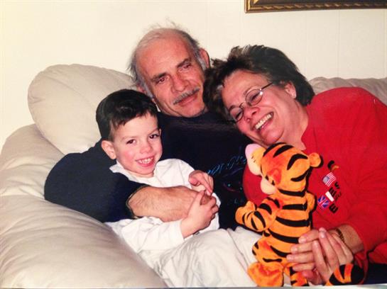 A man and woman with a child on a couch