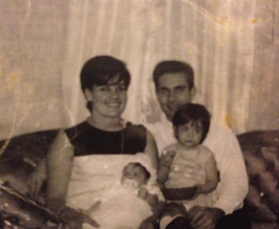 A man and woman sitting on a couch with a baby