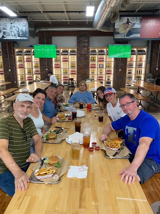 A group of people sitting at a table with food
