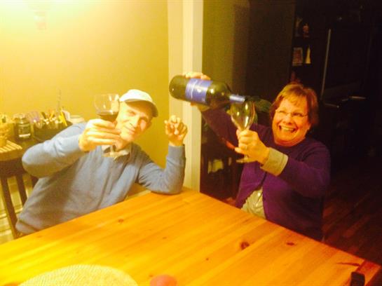 A man and woman holding wine glasses and drinking