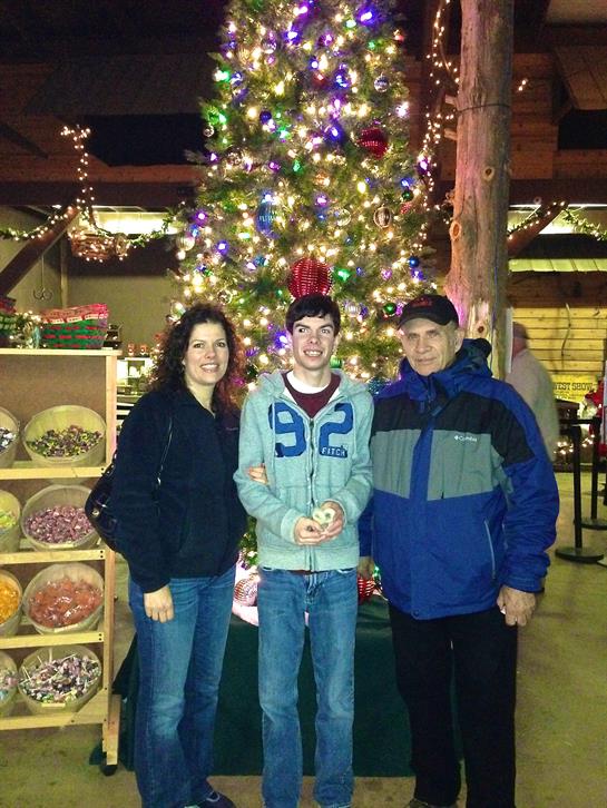 A group of people standing in front of a christmas tree