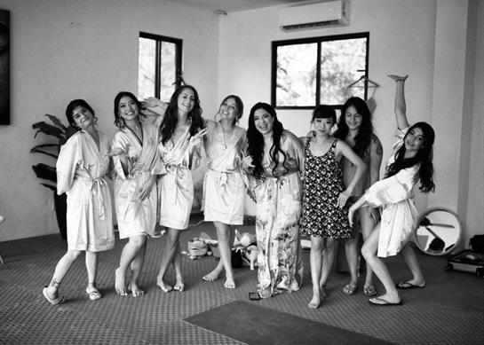 A cheerful gathering of friends in robes posing playfully at a spa retreat.