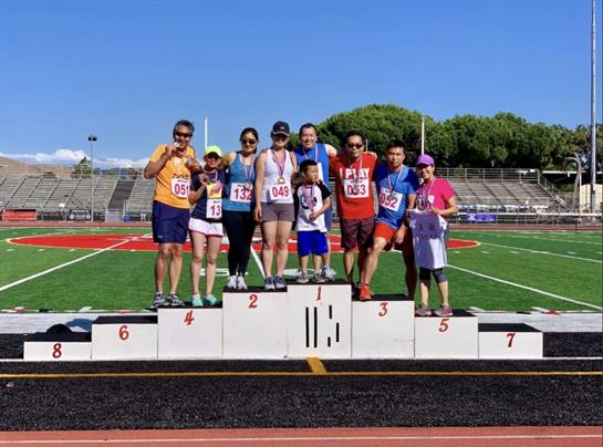 Participants proudly pose on the podium after competing in the local track and field event.