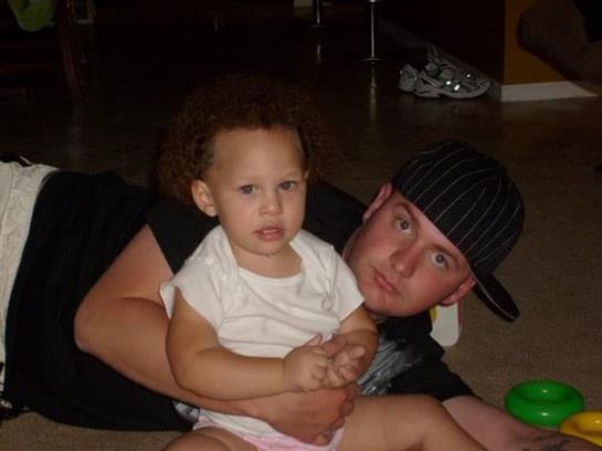 A young father engages with his child on the floor, creating a warm family atmosphere.