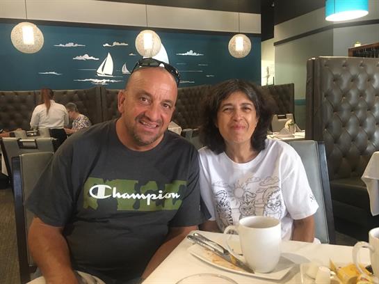 A couple sits at a table in a contemporary eatery, smiling while enjoying their meal together.