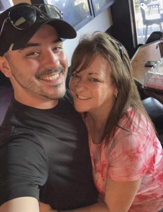 A man and woman embrace and smile warmly while enjoying a meal together.