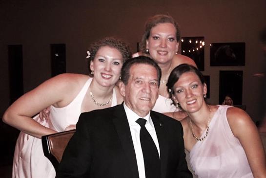 Four people share happy moments at a festive gathering in a refined setting.