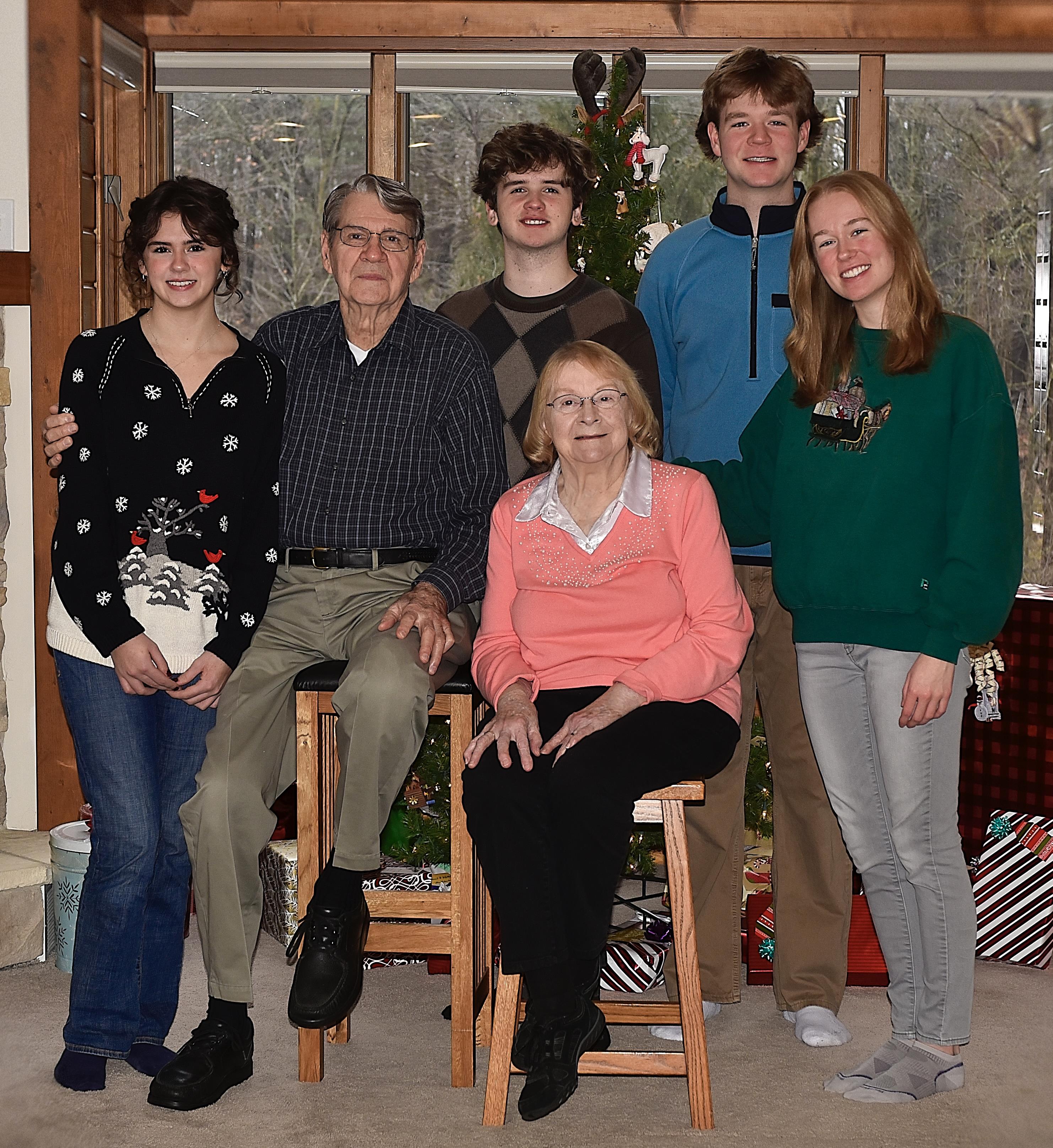 A family poses together in a warm living room, celebrating the holidays with joy.