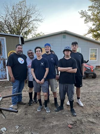 A group of men standing in front of a house