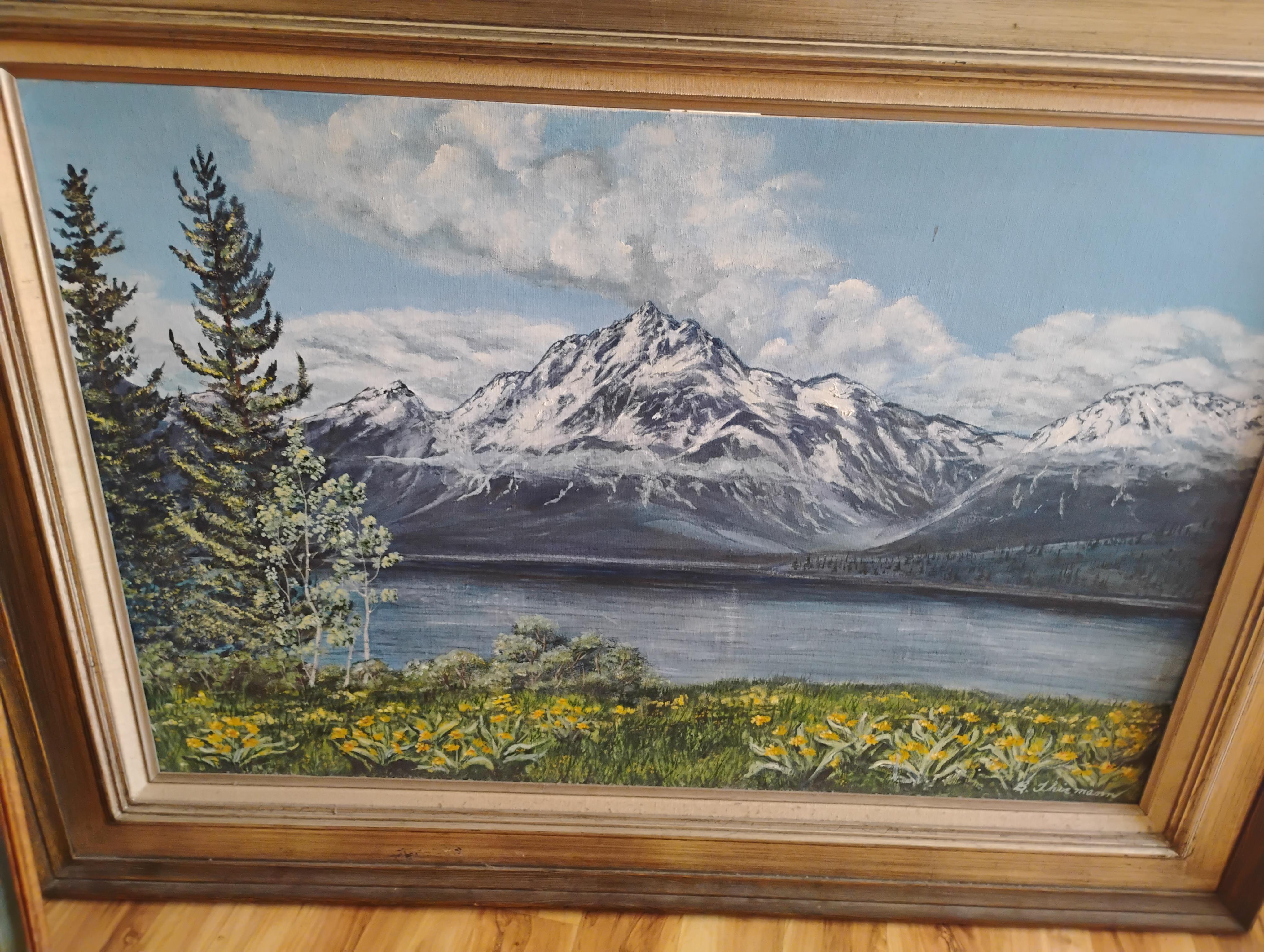Vibrant colors depict a majestic mountain range and peaceful lake under a blue sky with clouds.