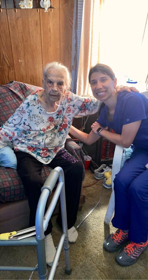 Caregiver and elderly woman sharing a joyful moment in a cozy living room.