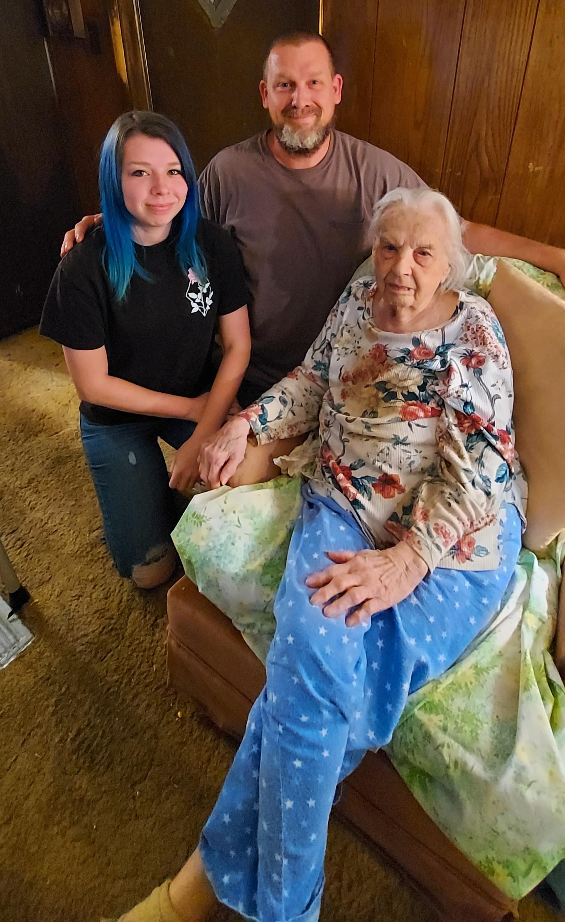 Three family members share a warm moment together in a living room filled with love.