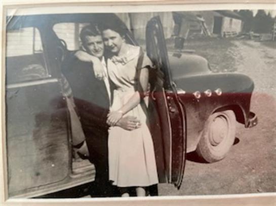 A man and woman standing in a car