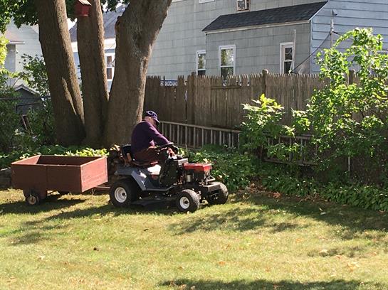 A man riding a lawnmower in a yard