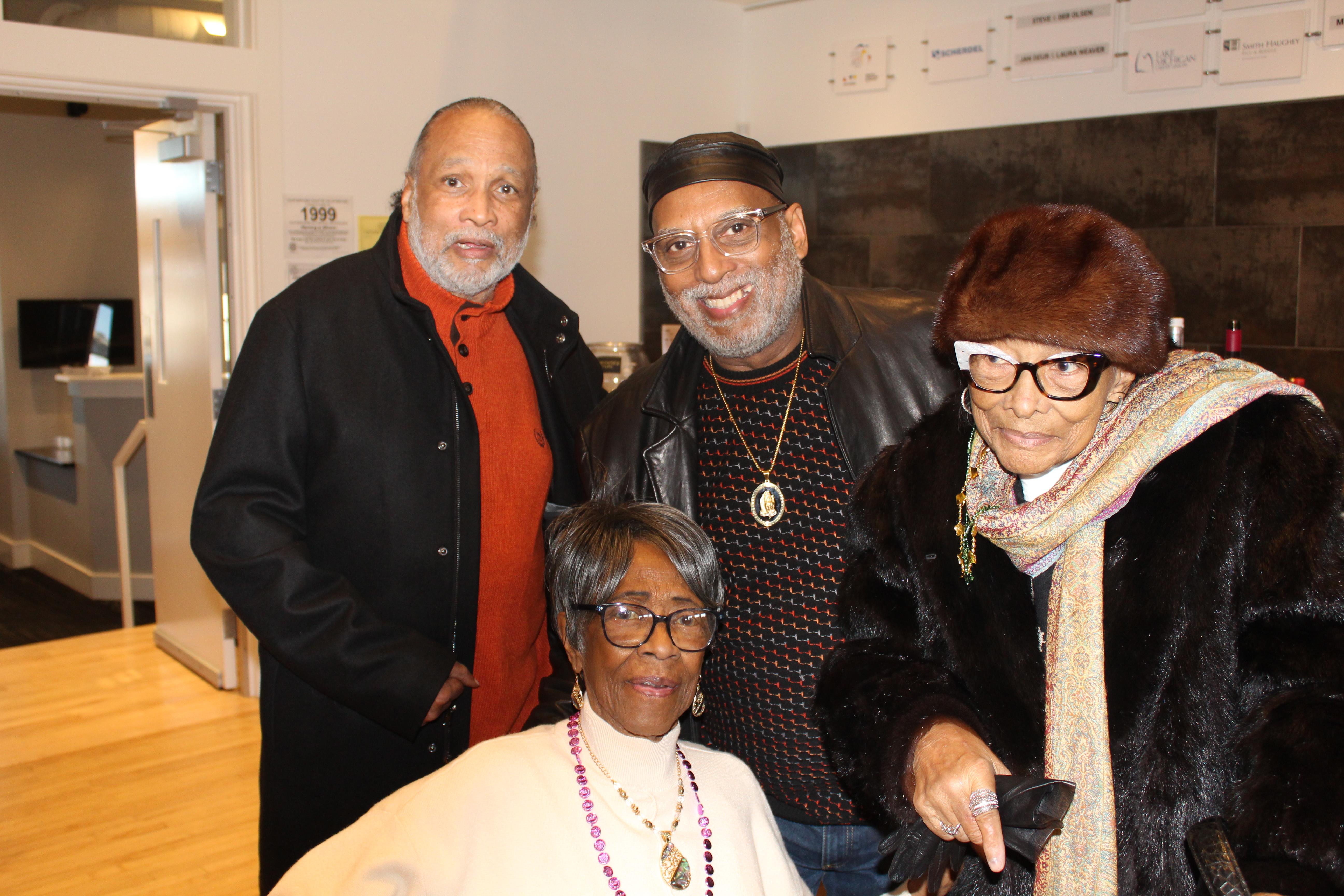 Four smiling elderly friends share a warm moment together in an inviting atmosphere.