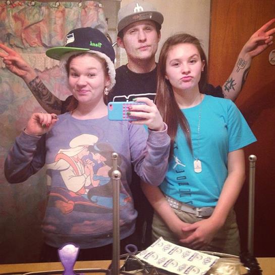 Friends gather for a fun selfie in a bathroom, displaying various hats and playful poses.
