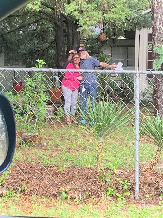 A man and woman standing in a yard