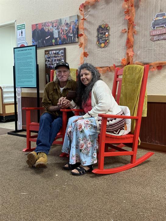 A man and woman sitting on a rocking chair