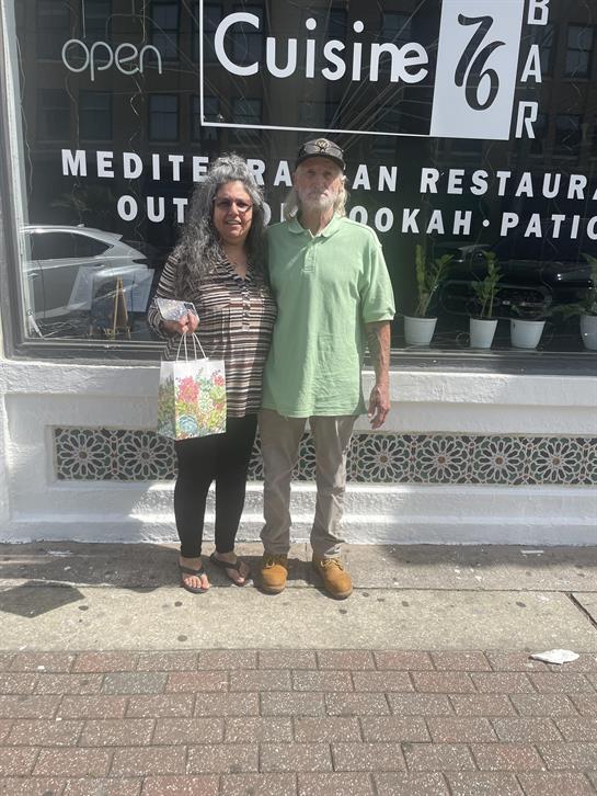 A man and woman standing in front of a store