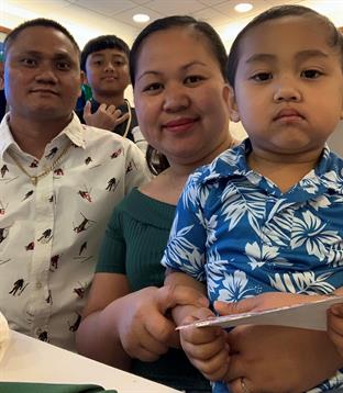 A family enjoys time together in a restaurant, sharing smiles and a playful atmosphere.