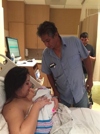 A man standing next to a woman lying in a hospital bed