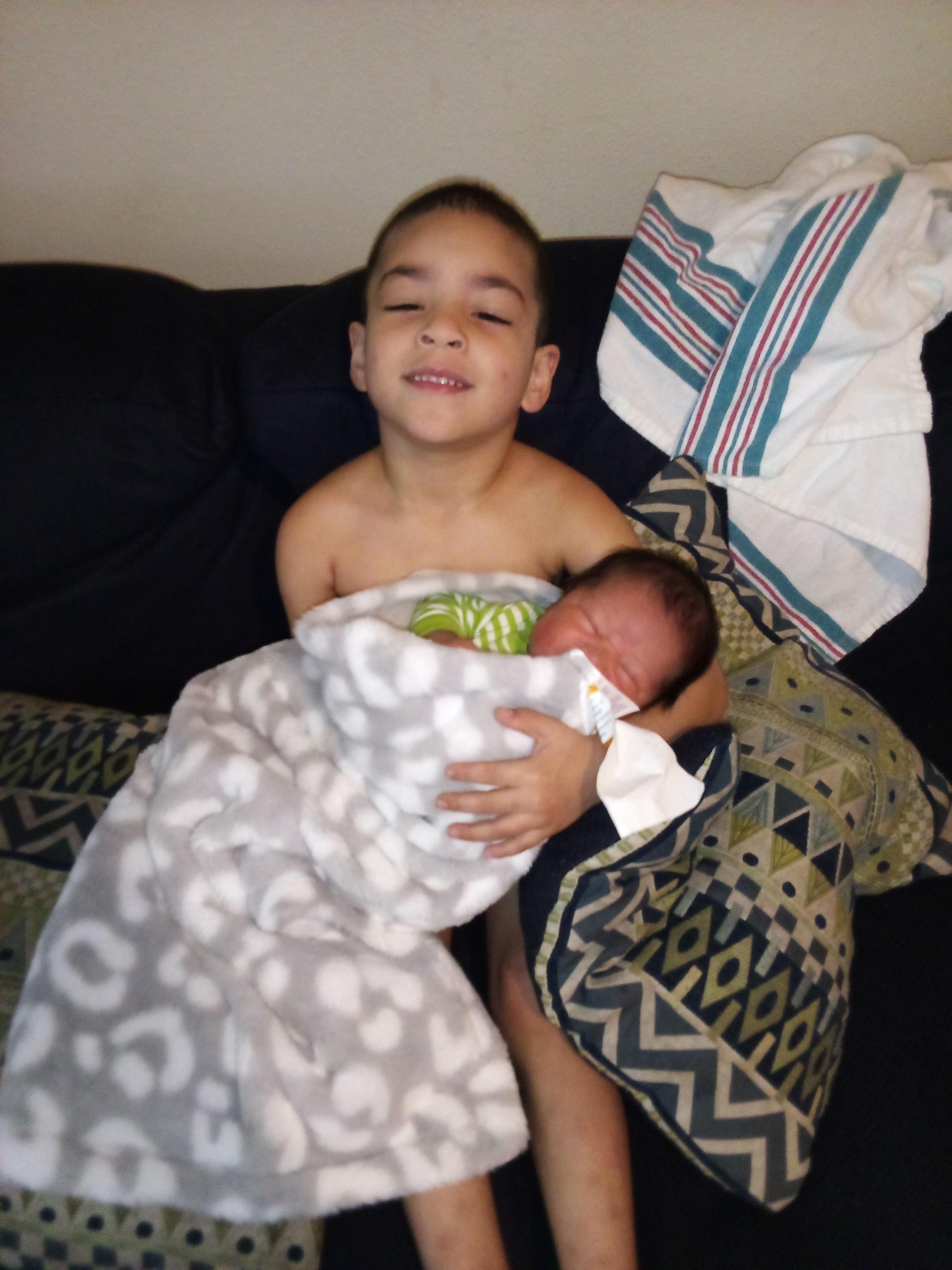 A boy holding a baby