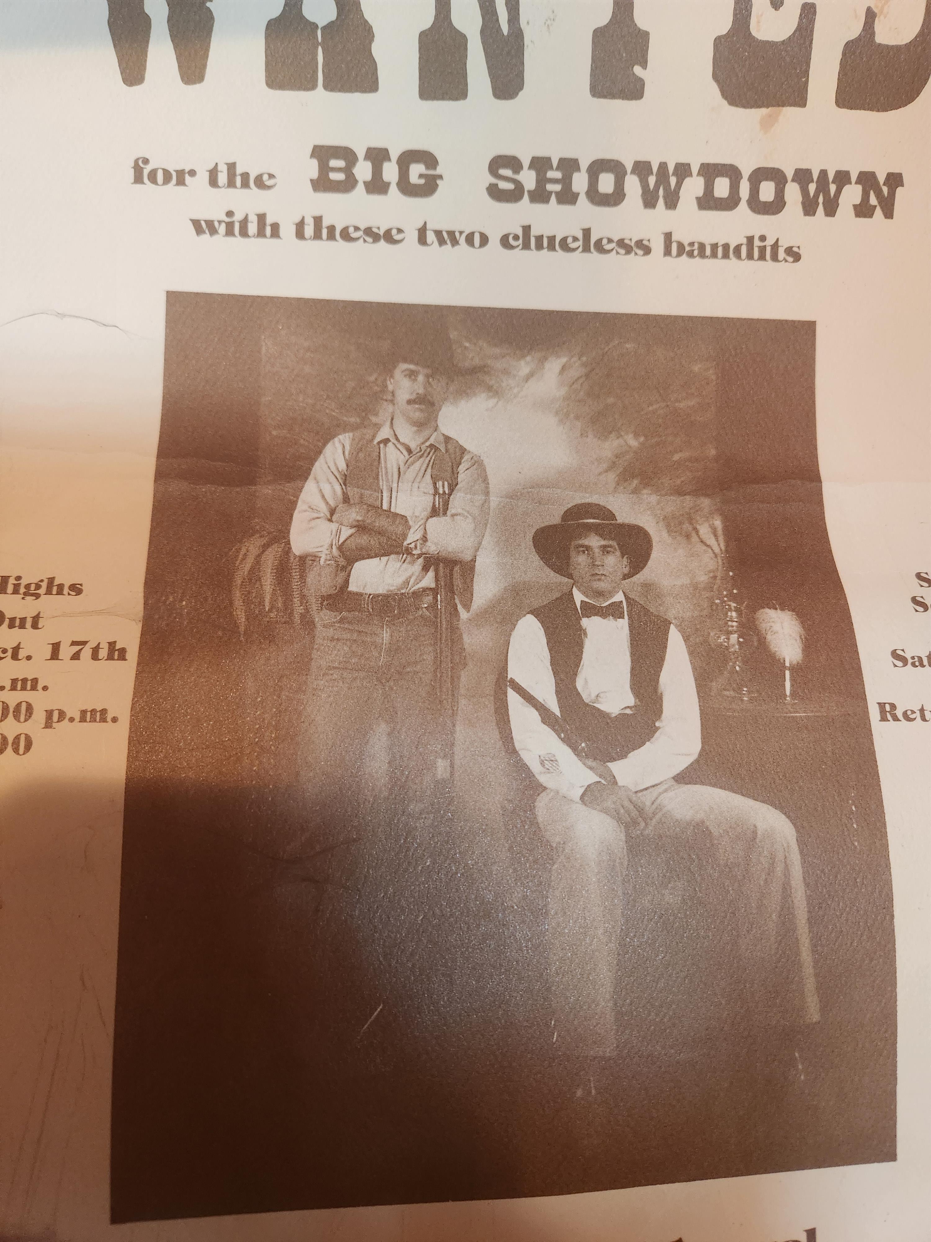 A wanted poster displays two bandits posing dramatically in a Western setting for a showdown.